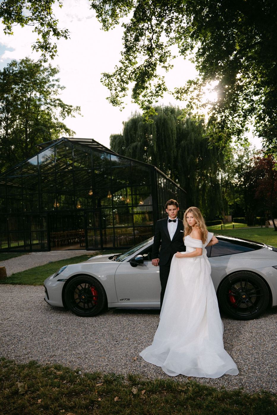 Brautpaar vor Glashaus und Porsche